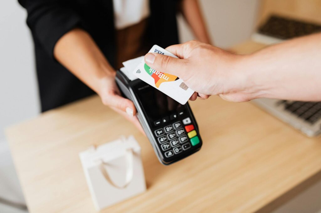 Close-up of contactless payment using a credit card at a modern POS terminal.